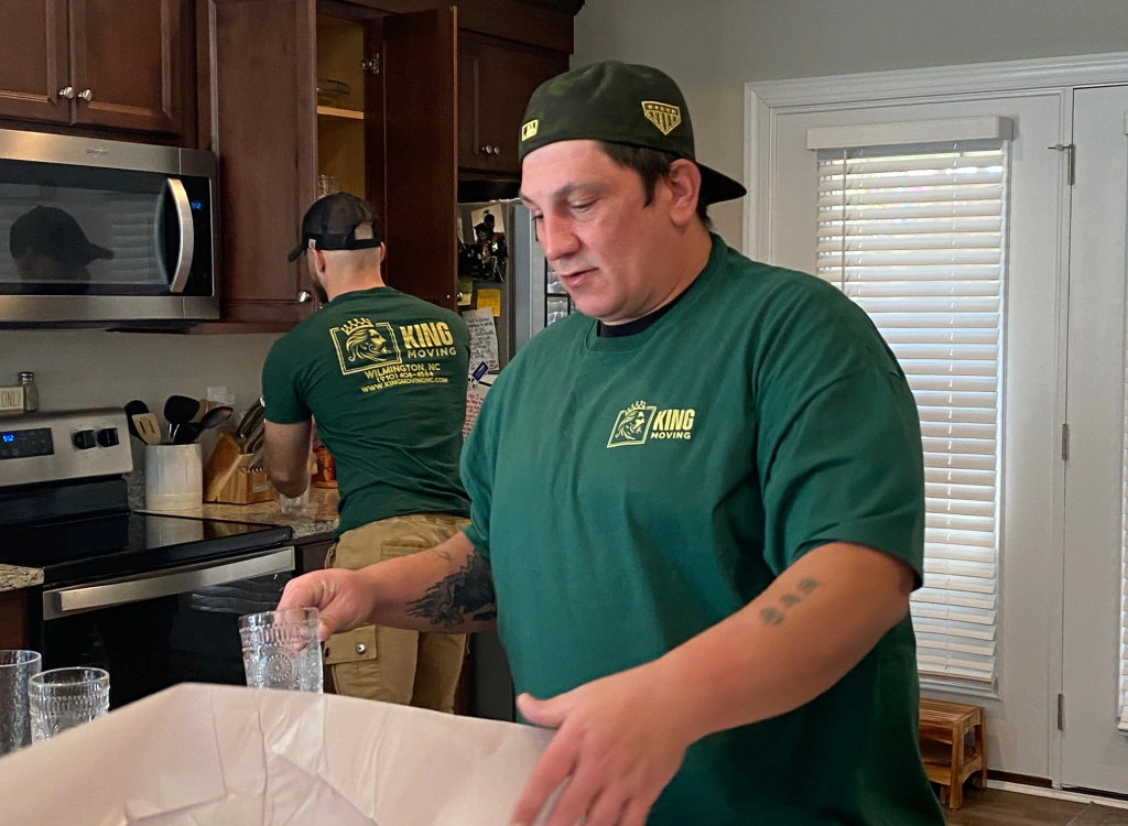 man packing cups and plates